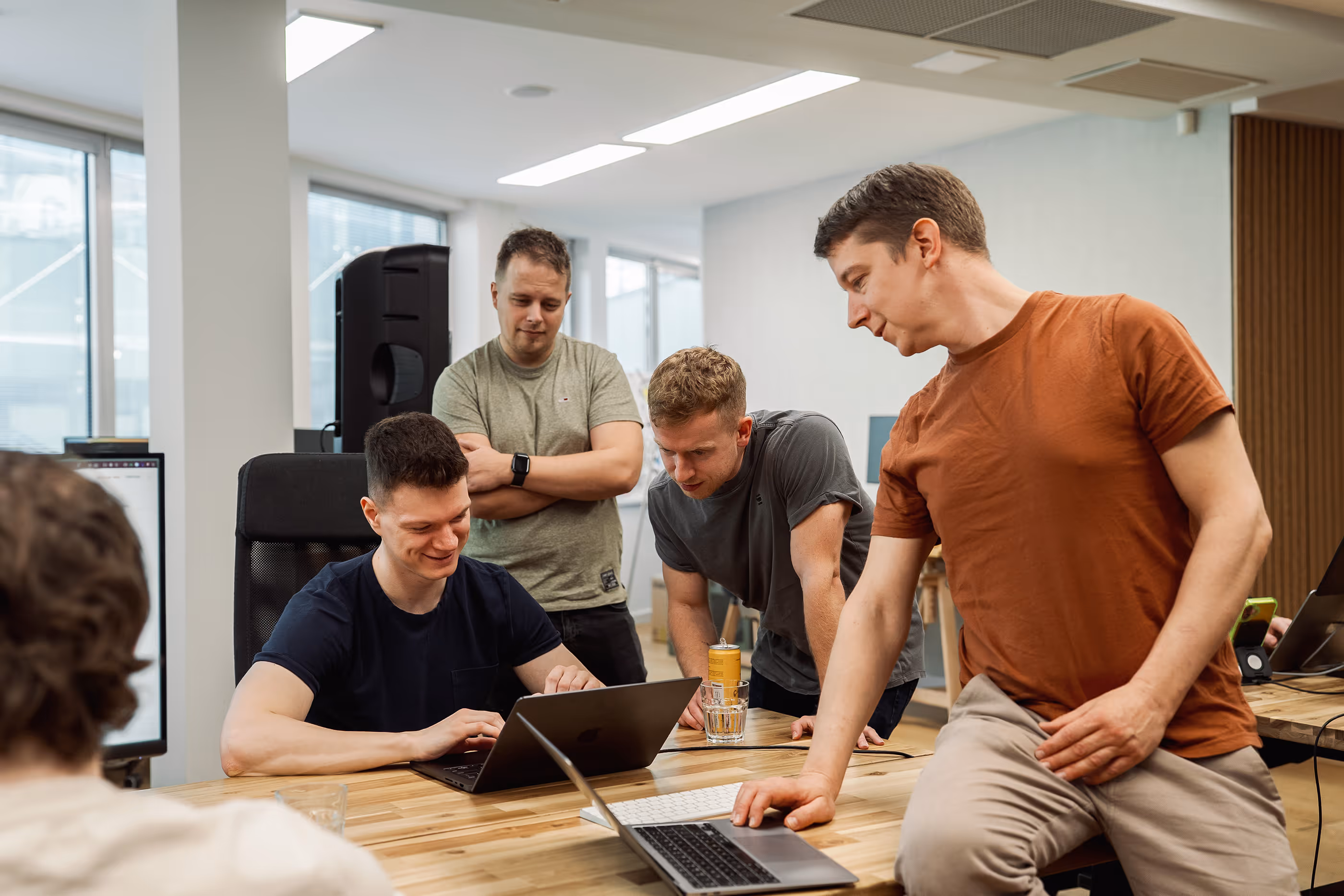 Outloud team reviewing work together around a laptop